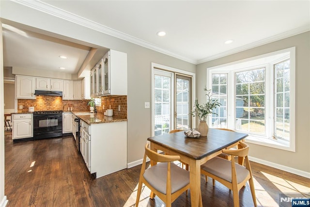 interior space with a wealth of natural light, white cabinetry, black appliances, and a sink