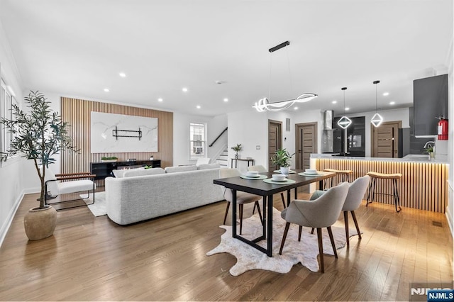 dining space with stairway, wood finished floors, baseboards, recessed lighting, and ornamental molding