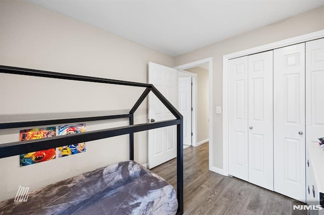 bedroom featuring a closet, baseboards, and wood finished floors