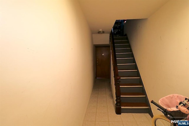 stairway with tile patterned floors