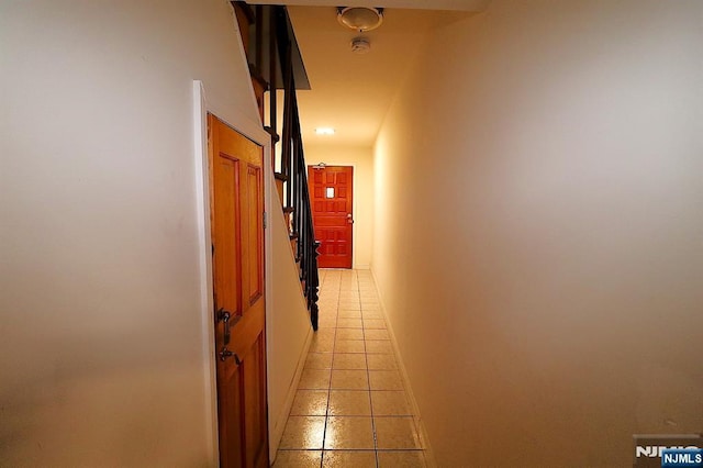 hallway featuring light tile patterned floors and baseboards