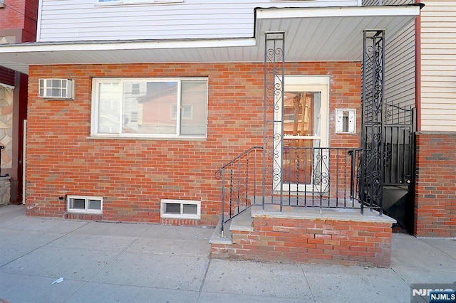 view of exterior entry featuring brick siding