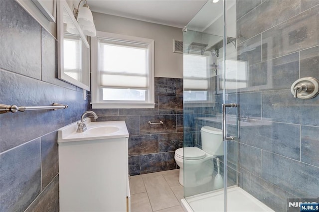 bathroom featuring tile patterned floors, visible vents, tile walls, and a stall shower