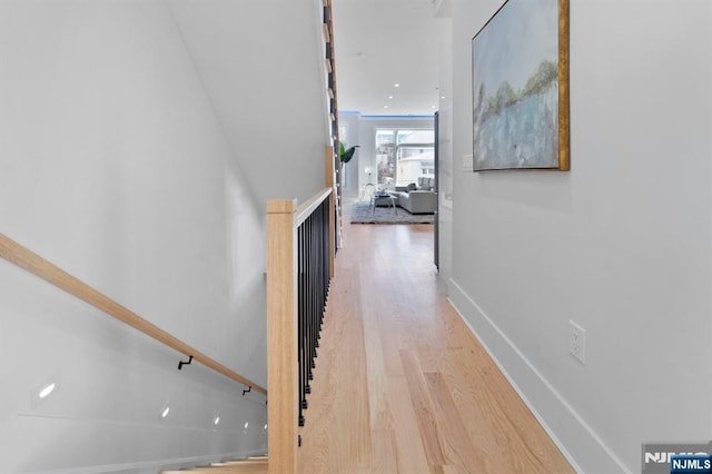 corridor featuring baseboards and light wood-style floors