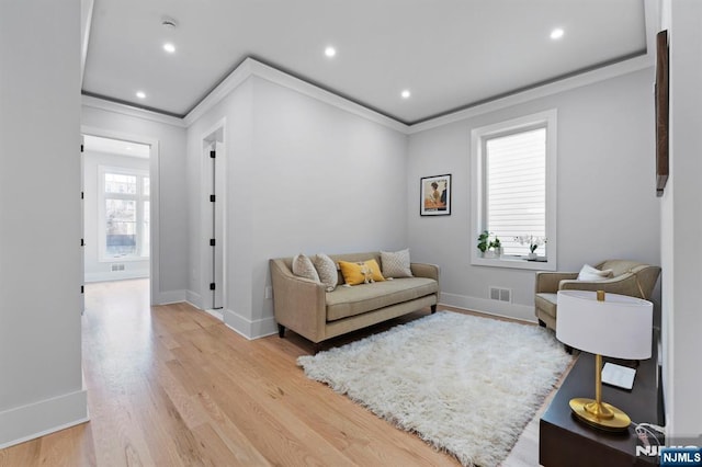 living area with recessed lighting, baseboards, crown molding, and light wood finished floors