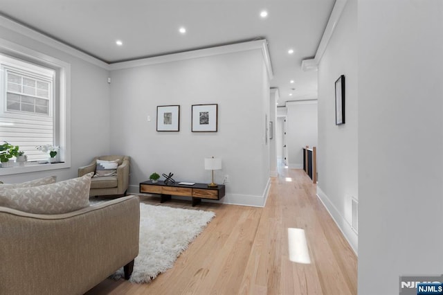 living area with visible vents, baseboards, light wood-style flooring, recessed lighting, and crown molding