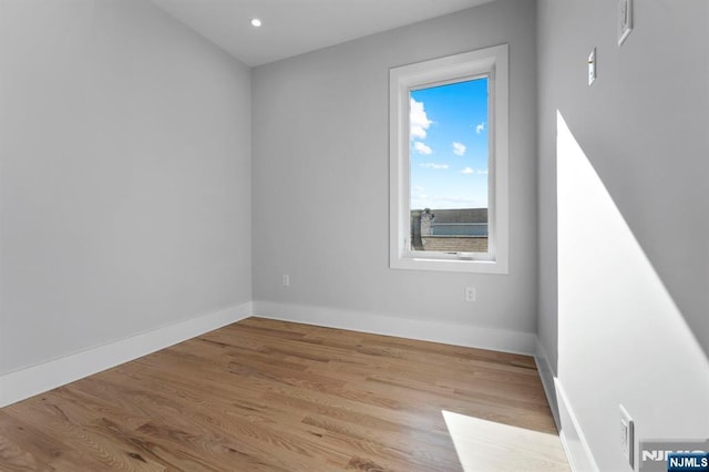 spare room featuring recessed lighting, baseboards, and wood finished floors