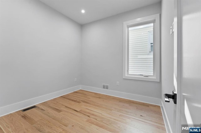 spare room featuring visible vents, baseboards, and light wood-style floors