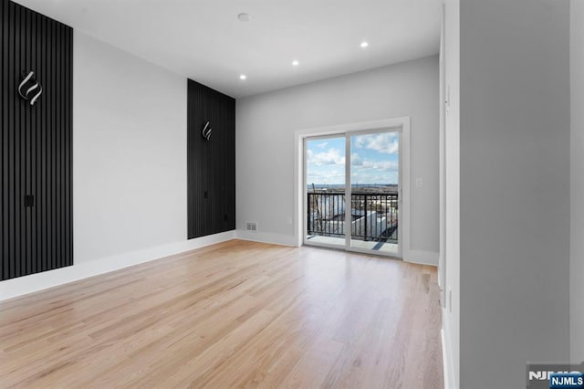 spare room with light wood-style flooring, recessed lighting, and baseboards