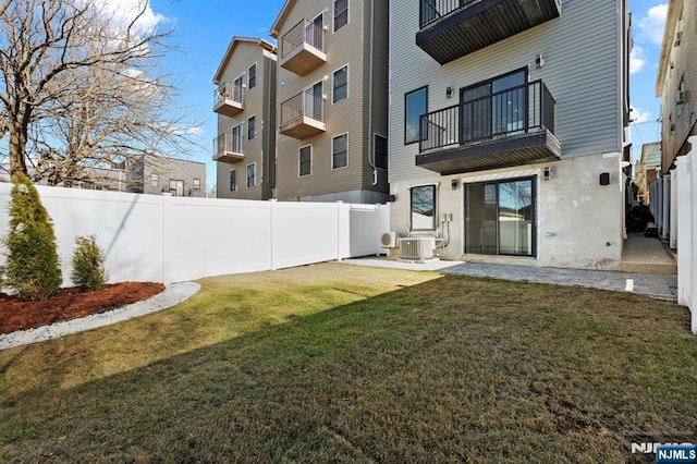 exterior space featuring stucco siding, a lawn, central AC, a fenced backyard, and a patio area