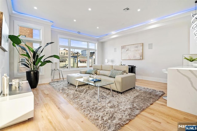 living room with visible vents, ornamental molding, wood finished floors, recessed lighting, and baseboards