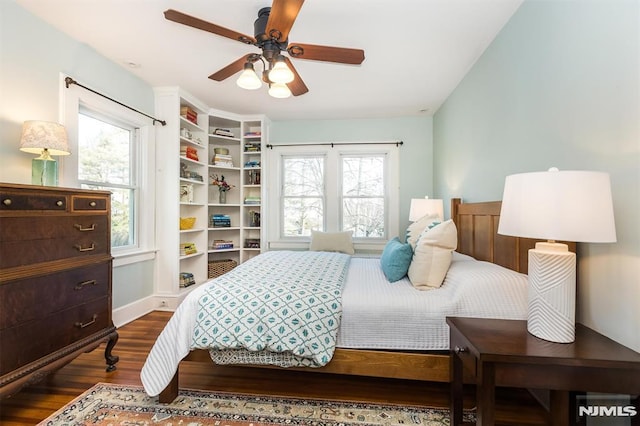 bedroom with multiple windows, dark wood-style floors, and ceiling fan