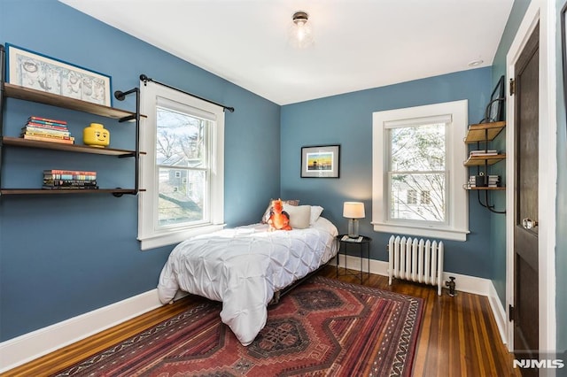 bedroom with multiple windows, radiator heating unit, and baseboards