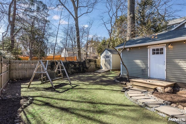 view of yard featuring an outbuilding, a shed, and a fenced backyard