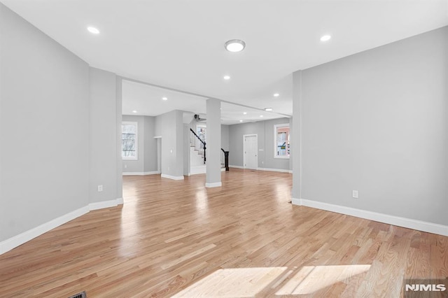 unfurnished living room featuring stairway, recessed lighting, light wood-type flooring, and baseboards