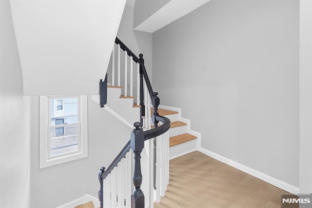 stairway featuring baseboards and wood finished floors