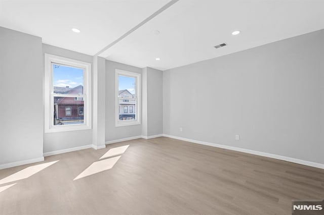 unfurnished room with recessed lighting, baseboards, and wood finished floors