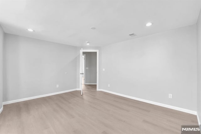 spare room featuring recessed lighting, baseboards, and light wood-type flooring