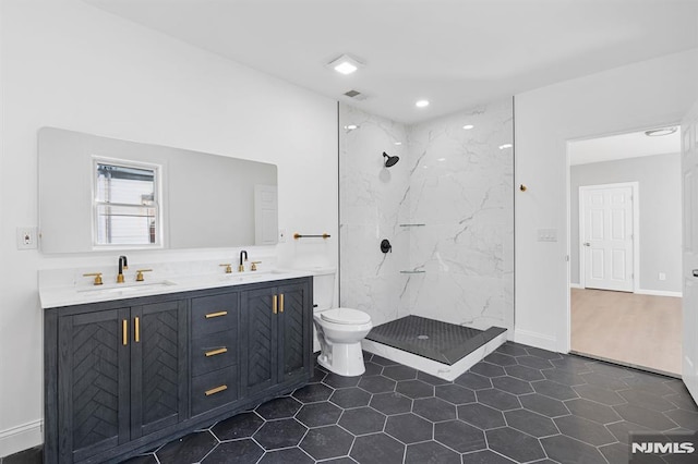 full bathroom featuring a sink, a marble finish shower, visible vents, and double vanity