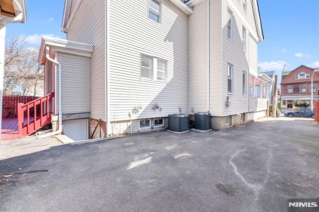 view of property exterior featuring central air condition unit and a residential view