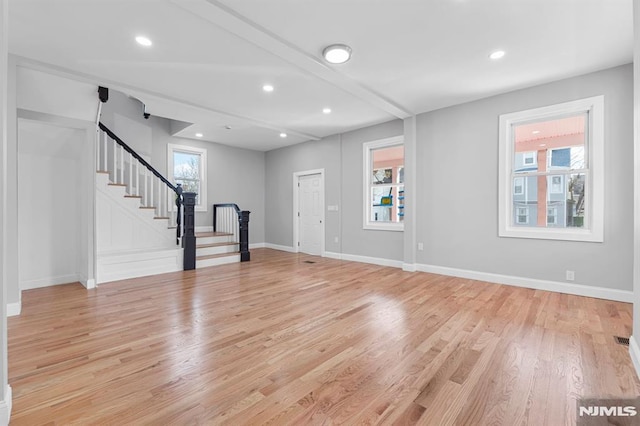 foyer with stairway, light wood-style flooring, and a wealth of natural light