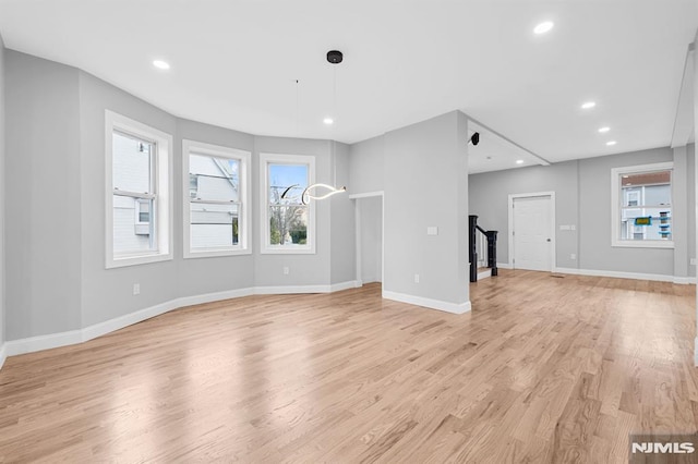 unfurnished living room featuring recessed lighting, baseboards, and light wood-style floors