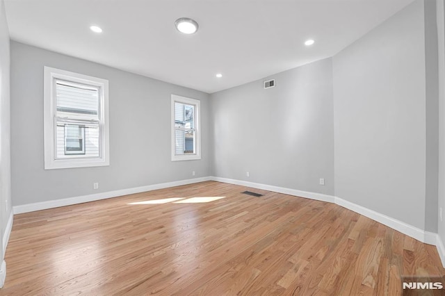 empty room with recessed lighting, light wood-style floors, visible vents, and baseboards