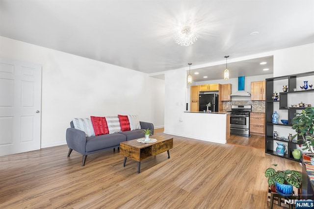 living room with recessed lighting, baseboards, and light wood-style floors