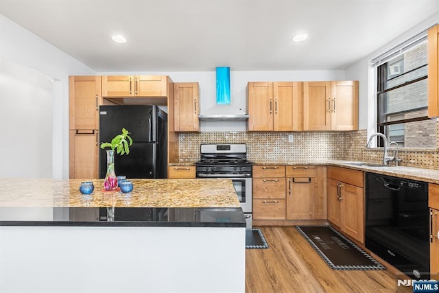 kitchen featuring a sink, backsplash, black appliances, and light wood finished floors