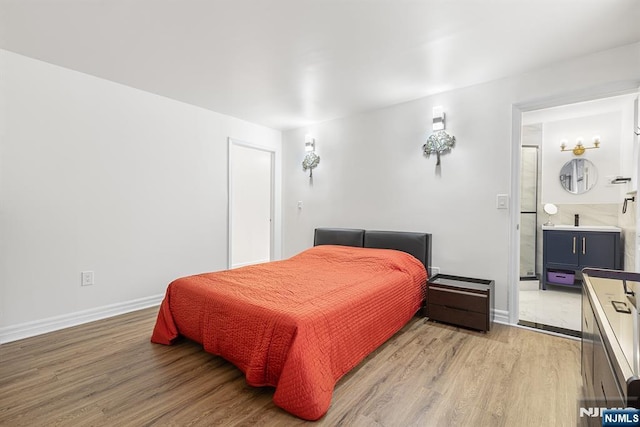 bedroom with baseboards, light wood finished floors, and connected bathroom