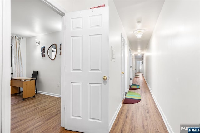 hallway featuring wood finished floors and baseboards