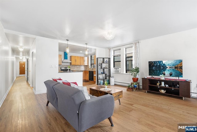 living room featuring light wood-style flooring, cooling unit, and baseboards