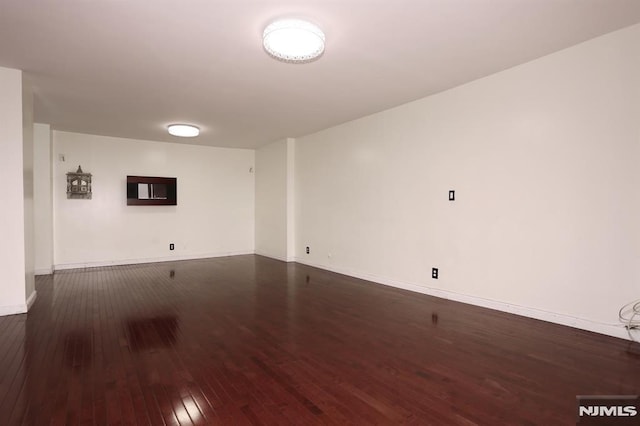 empty room with hardwood / wood-style floors and baseboards