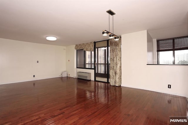 interior space with radiator, wood finished floors, and baseboards