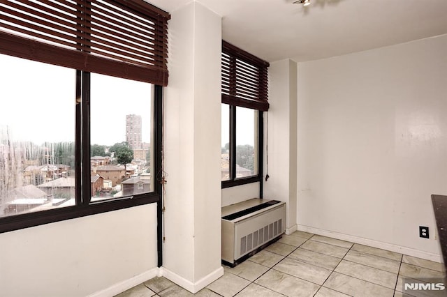 interior space with tile patterned floors, radiator heating unit, and baseboards