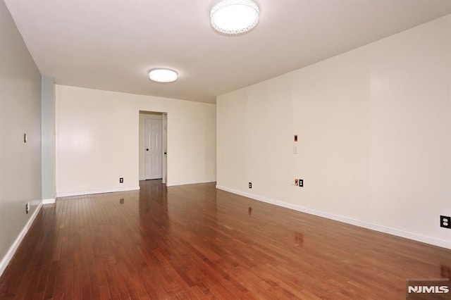 unfurnished room with baseboards and hardwood / wood-style floors