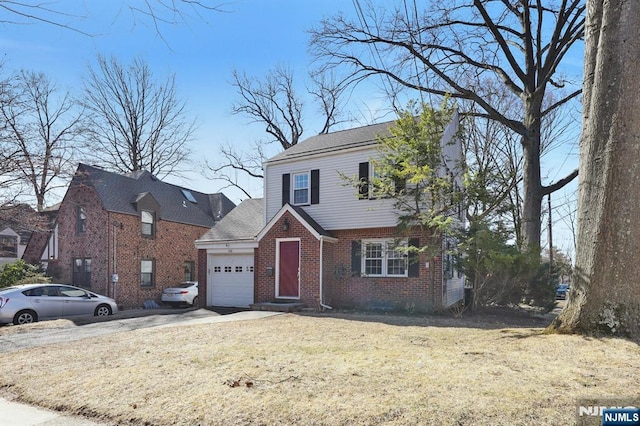 view of front of property with a garage, brick siding, concrete driveway, and a front yard