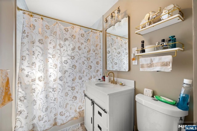 bathroom featuring toilet, vanity, and a shower with curtain