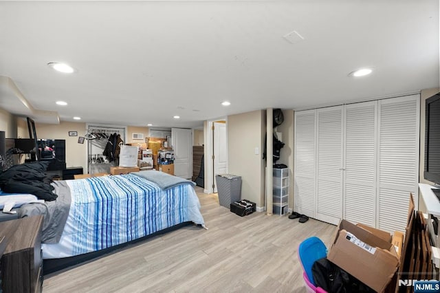 bedroom featuring recessed lighting, two closets, and light wood-style flooring