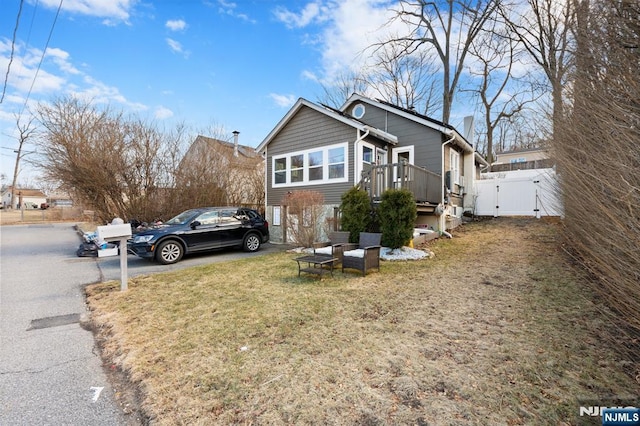 view of front facade with fence, a front yard, and a gate