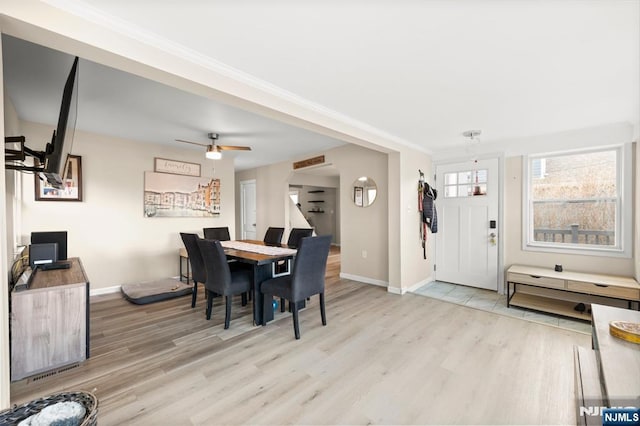 dining area with baseboards, a ceiling fan, wood finished floors, and crown molding