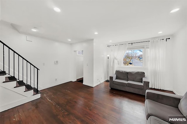 living room featuring recessed lighting, baseboards, wood finished floors, and stairs