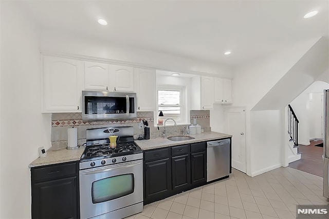 kitchen featuring tasteful backsplash, recessed lighting, stainless steel appliances, white cabinetry, and a sink