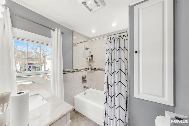 bathroom with visible vents, toilet, vanity, and shower / tub combo