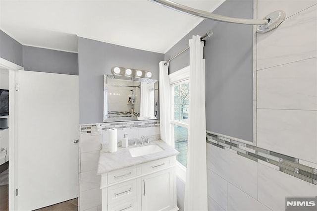 full bathroom with vanity and tile walls