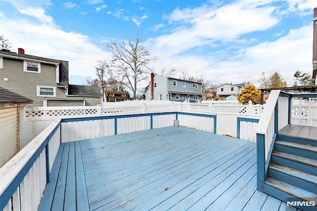 wooden terrace featuring a residential view and fence