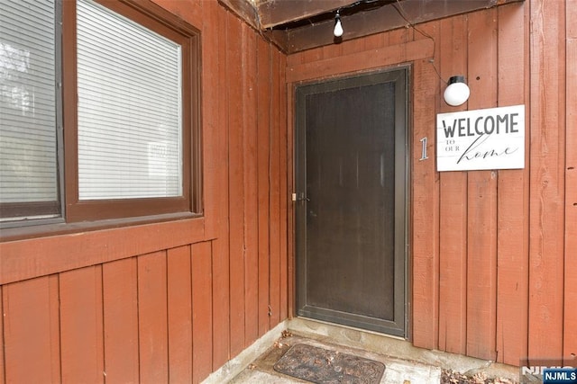 property entrance featuring board and batten siding