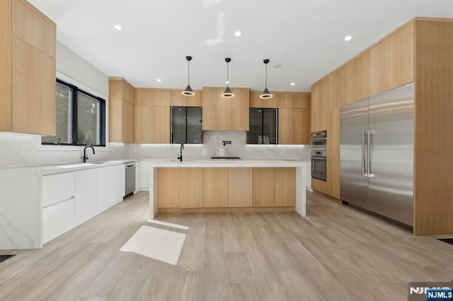 kitchen featuring light brown cabinetry, appliances with stainless steel finishes, modern cabinets, and light countertops