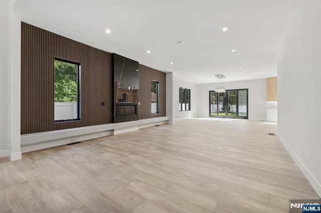 unfurnished living room featuring recessed lighting, light wood-type flooring, and baseboards