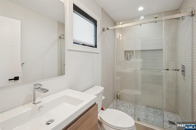 full bath featuring vanity, a shower stall, and toilet